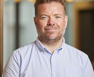 Man in blue shirt smiling to the camera